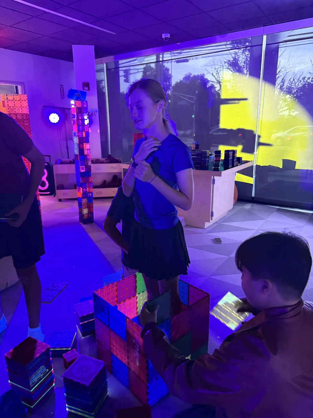 A teen building beside a glowing magnetic tile tower